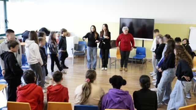 Le volontarie di Donne e Giustizia circondate da una classe di ragazzi e ragazze